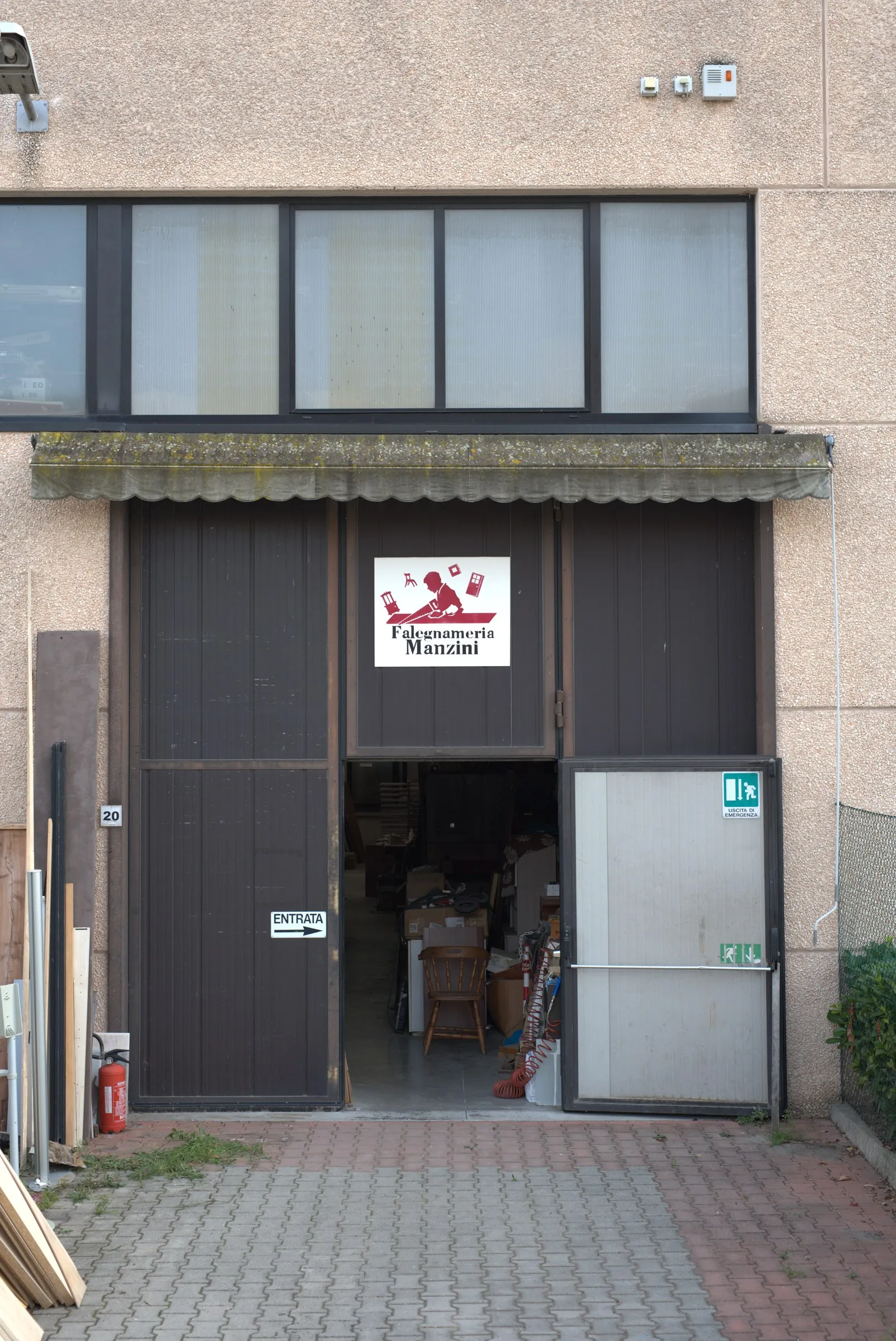 L'ingresso della bottega in via Guido Rossa 20, con l'insegna Falegnameria Manzini sul portone